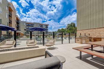 A modern outdoor seating area with a view of apartment buildings.